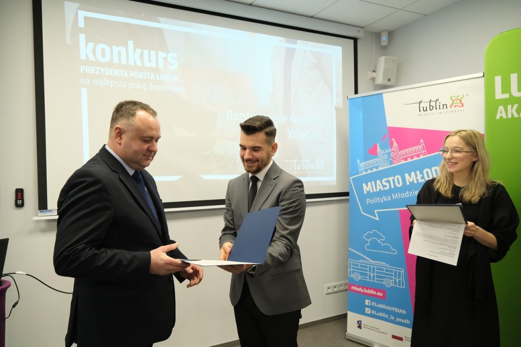 Organizator wręcza nagrodę pierwszemu z wyróżnionych.