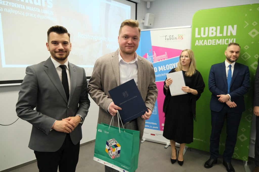 Laureat nagrody pozuje do zdjęcia.