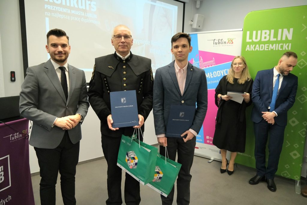 Laureat nagrody wraz z promotorem pozują do zdjęcia. Promotor ubrany w odświętny mundur górniczy.