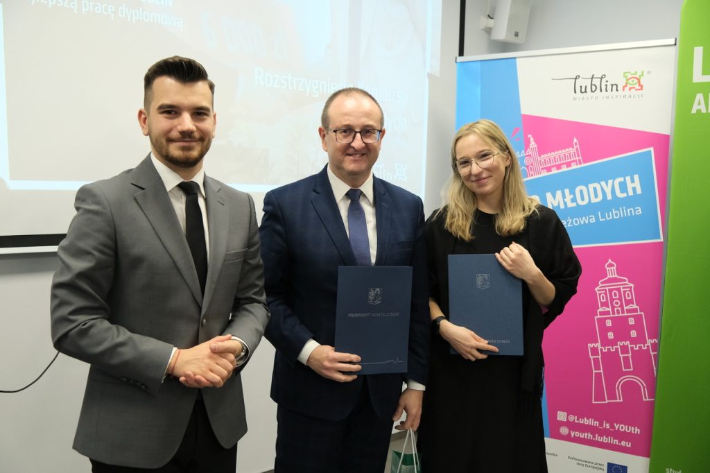 Laureat nagrody pozuje do zdjęcia.