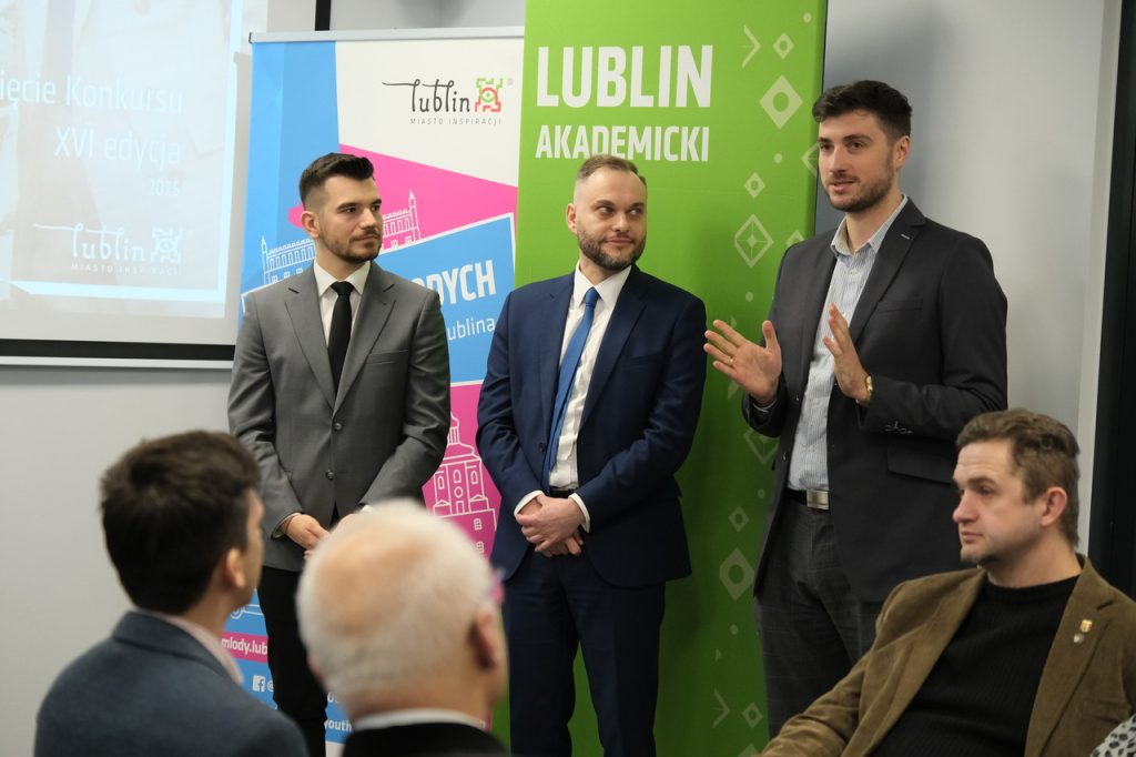 Na zdjęciu sześcioro ludzi. Przemawiają do zgromadzonych osób.